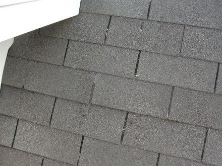 Damaged shingles from ice dam hacks